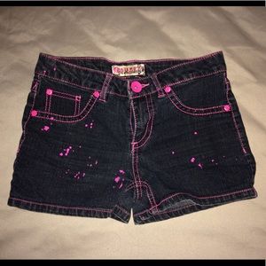 Black jean shorts with pink paint splatters